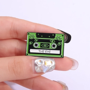 Pin's vintage en émail en forme de cassette verte avec illustrations d'yeux sur fond blanc