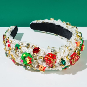 Close-up of white tweed Christmas headband with red gifts, green wreaths and pearls