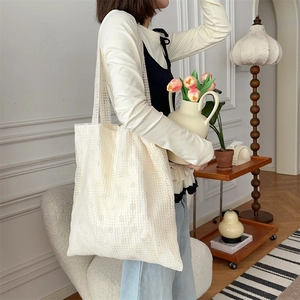 Detail of floral lace mesh tote bag with intricate crochet flower patterns on shoulder strap