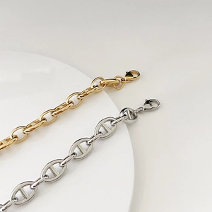 Close-up of 18k gold and silver geometric link bracelets with lobster clasp and high polish