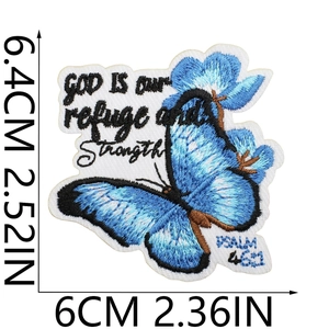 Macro shot of blue butterfly embroidery patch with God is our refuge religious text