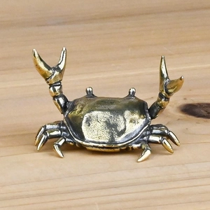 Detail of vintage brass crab figurine with lifelike pincers and antique bronze finish