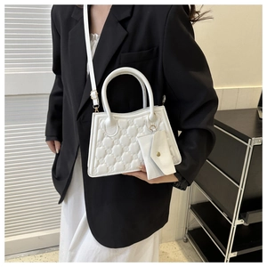 Detail of white quilted crossbody bag with gold hardware and small matching coin purse