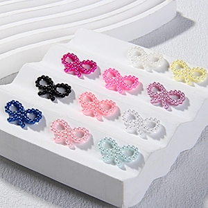 Colorful ABS pearl bow tie charms for DIY phone cases and cream glue crafts on white stand