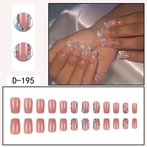 Short square press-on nails in nude pink with light blue flowers and tiny rhinestones