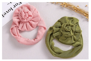 Detailed close-up of ribbed knit baby headbands with large fabric rose flower accents