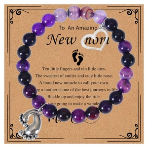 Detail of pink zebra stone bracelet with baby feet charm and heart on a greeting card