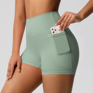 Gros plan détaillé de la poche latérale sur un short de yoga vert clair taille haute
