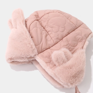 Detalle del gorro rosa de invierno con orejas de conejo y diseño acolchado de oso