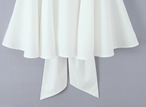 Detail view of a white princess skirt with layered pleats and a large ribbon bow