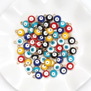 Mix of colorful 8mm evil eye charms for DIY jewelry making in a white ceramic dish