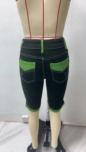 Detailansicht der Damen-Jeansshorts in Schwarz mit grünen Kontrasttaschen und Schlaufen
