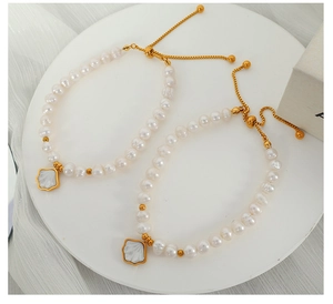 Detail of elegant natural freshwater pearl bracelet with gold hardware on stone base