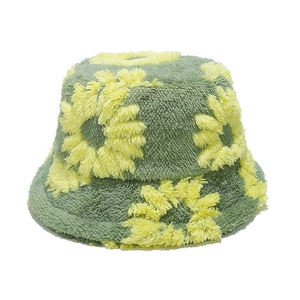 Detail of plush teddy fleece texture with yellow sunflower pattern on green bucket hat
