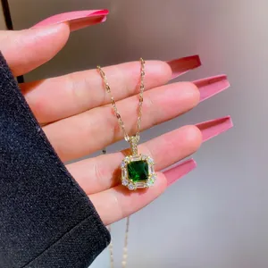Close-up of gold necklace featuring emerald green zircon pendant with pave setting