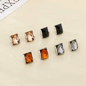 Detail showing square cut crystal earrings in champagne, black, amber, and grey with 18k gold