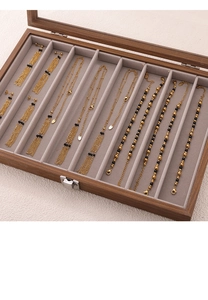 Detail of vintage gold chain necklaces and agate bead earrings in a wood jewelry box