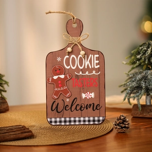 Wooden gingerbread man welcome sign hanging on a Christmas tree with a rustic twine handle