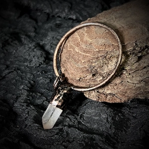 Dettaglio macro del ciondolo in cristallo naturale con anello in rame rustico artigianale