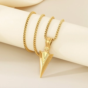 Close-up of golden stainless steel arrow pendant on a sleek woven chain necklace