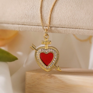 Golden heart pendant necklace with red enamel, crystal accents and cross arrow design