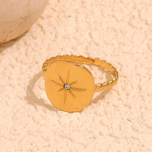 Detailed close-up of 18K gold plated starburst ring with zircon on stone surface
