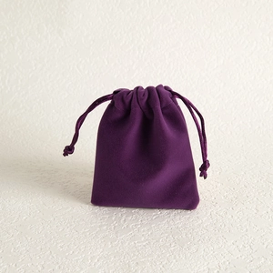 Macro detail of high-quality dark purple velvet jewelry drawstring pouch with soft texture