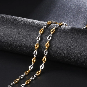 Macro shot of 4.5mm two-tone coffee bean link bracelet in gold and silver stainless steel