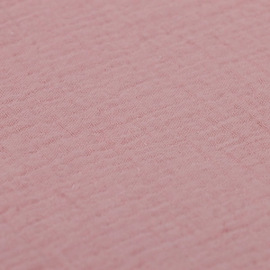 Close-up of soft pink double-layer muslin cotton fabric with breathable crinkle texture