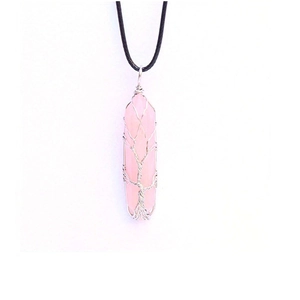 Detail of handmade silver wire wrapped Tree of Life pendant with pink rose quartz crystal