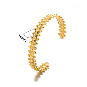 Close-up of a 10mm wide gold studded cuff bracelet with a punk style spike texture