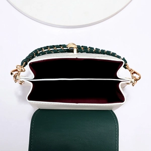 White textured PU leather bucket bag with dark green woven chain strap and dual compartments