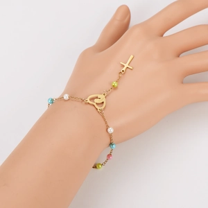 Bracelet en acier doré avec breloques cœur et croix et perles colorées porté au poignet