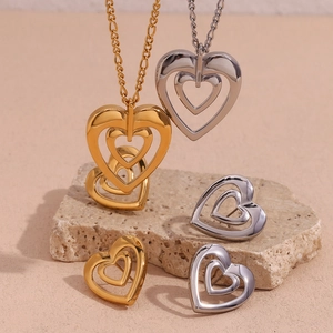 Close-up of gold and silver hollow heart necklaces and earrings set on natural stone