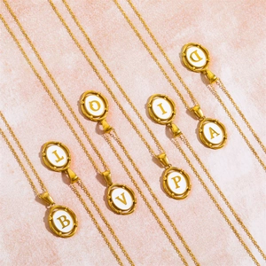 Gold oval alphabet pendant necklace with initials B L V P I A D on pink background