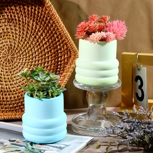 Dettaglio di vasi in ceramica a onde pastello con piante grasse finte decorative