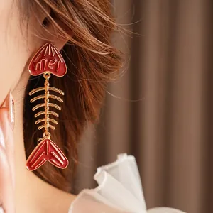 Stylish fish bone drop earrings with red enamel heart and me text in gold finish