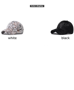 Detail view of cotton baseball caps showing white leaf print and classic black fabric
