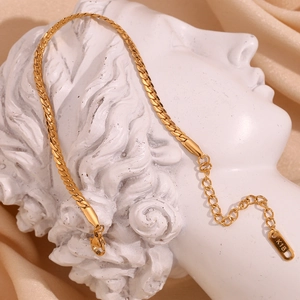 Detail of 18K gold plated thick NK chain bracelet on a white artistic sculpture
