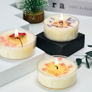 Macro shot of handmade tea light candle with purple dried flower petals in a clear container
