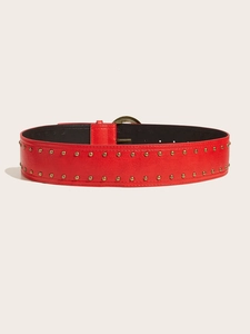 Détail de ceinture punk en cuir rouge avec clous dorés et texture de surface