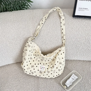 Detail of corduroy crossbody bag with heart bow pattern and adjustable shoulder strap