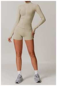 Detail of seamless beige yoga set featuring long sleeve zip jacket and tight sports shorts