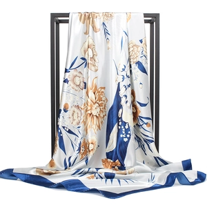 Elegant 90cm silk scarf with ink floral print and navy border on a minimal black stand