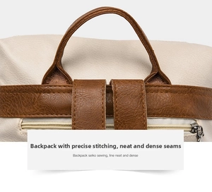 Close-up of contrast stitching on beige soft leather backpack with brown top handle and metal zipper