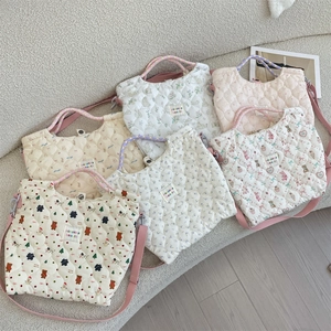 Détails d'un sac à main en coton matelassé avec poignées tissées et boucles en métal