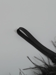 Detailed view of elastic band with black feather trim on an off-shoulder summer dress