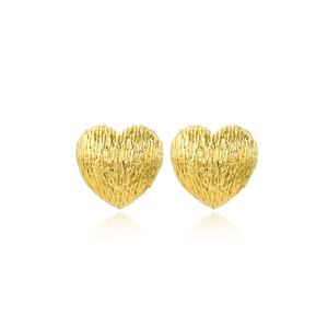 Macro detail of French vintage heart studs with a textured lava brushed gold finish