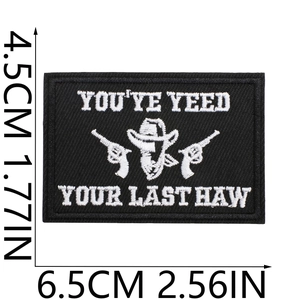 Detail of western cowboy patch with revolvers and hat embroidery measuring 4.5x6.5cm