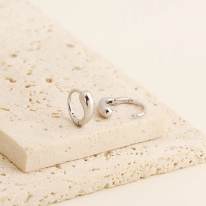 Close-up of minimalist S925 sterling silver earrings with visible metal hallmarks